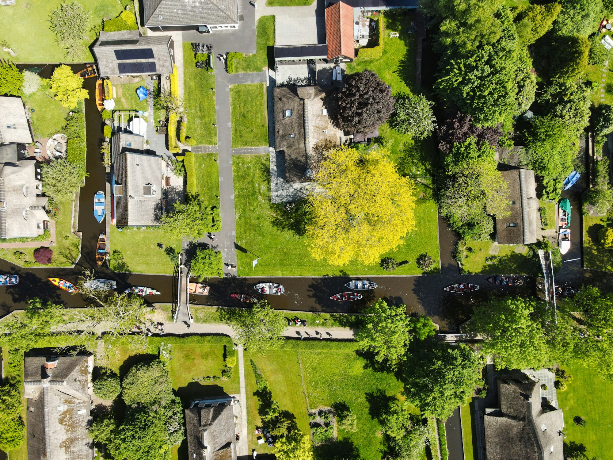 Aerial top view of Giethoorn village with green trees,houses and boats in a river